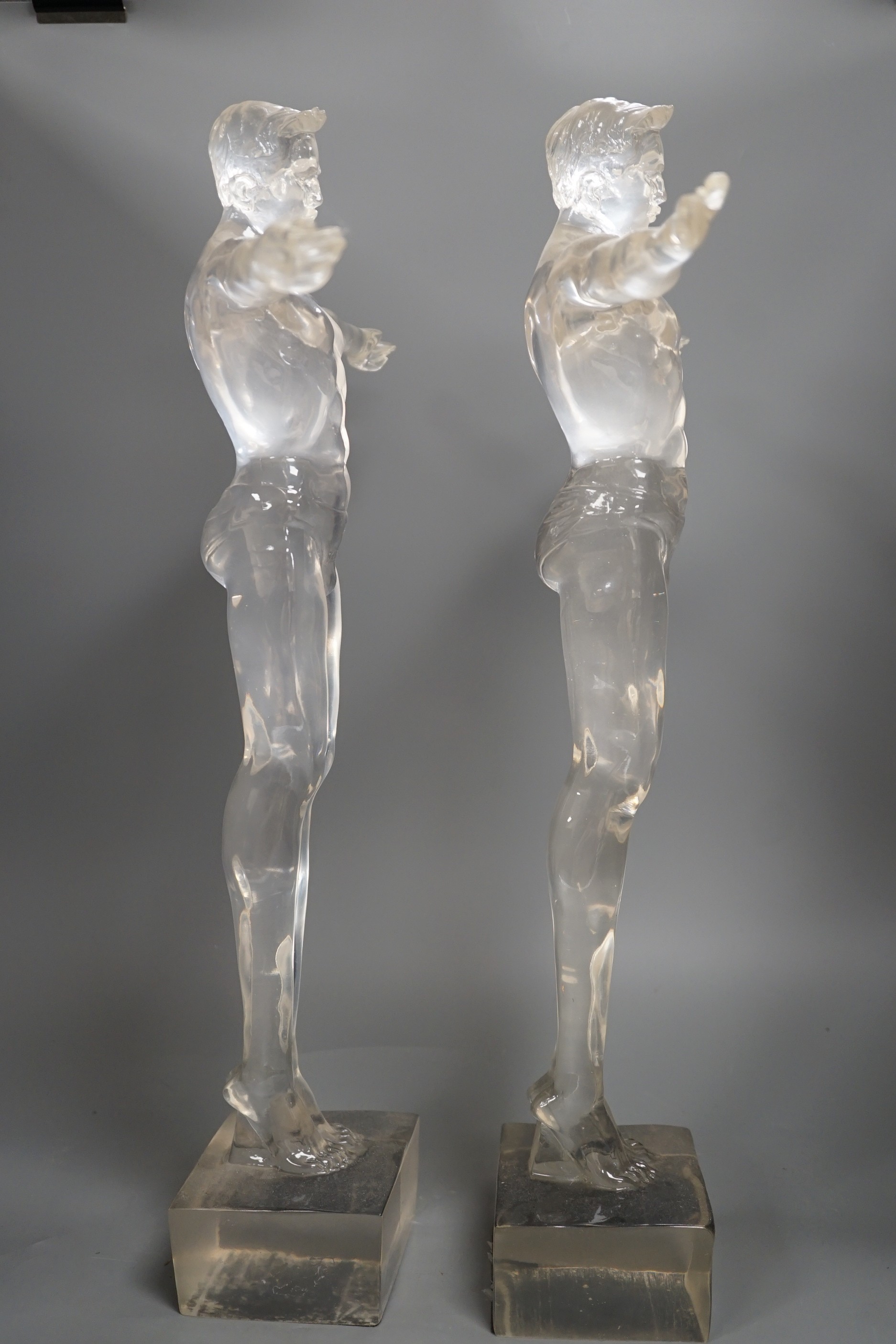 A pair of clear perspex models of male swimmers, 57cms high